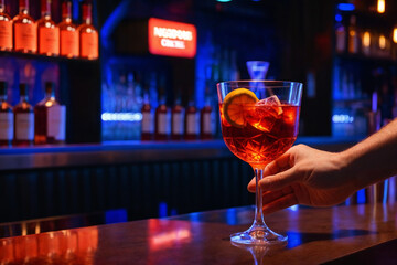 man hand hold glass red coktail in bar
