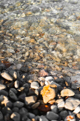 Textura de agua sobre orilla de rocas en la playa
