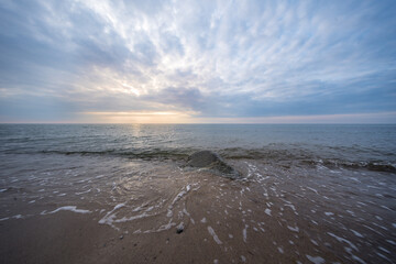 Sandstrand mit Steinen bei schöner Lichtstimmung