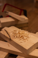 A pile of wood shavings rests on a wooden plank
