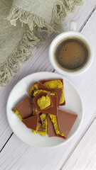 Flat lay of Trendy Dubai style chocolate with coffee on the white wooden table