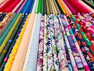 Colorful fabric rolls showing various patterns and colors, creating a vibrant display