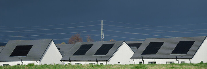 Obraz premium Solar panels installed on home roofs at new housing development