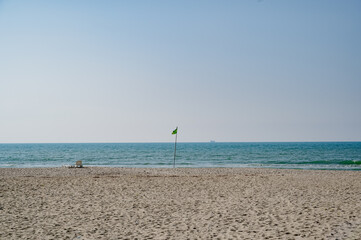 Green flag on a beach. Safe to swim. Beautiful beach in Durres.  The green flag indicates the presence of calm surf conditions. nice, safe day to enjoy at the beach.