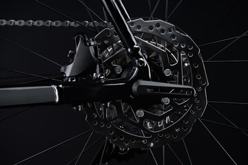 Rear wheel of black gravel bike on dark background.