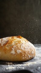 Freshly baked sourdough homemade bread with intricate scoring and flour dust against a dark background