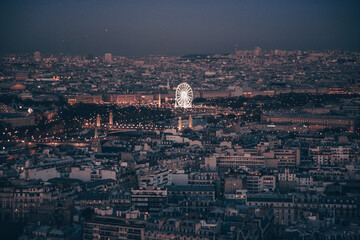 Obraz premium A city skyline of Paris with a tall building in the middle. The sky is dark and the city is lit up