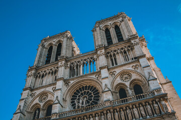 Fototapeta premium A large white church Paris Notre Dame with two towers and a large white wall. The church is located next to a river