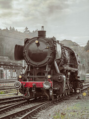 Fototapeta premium A old train is on the tracks. The train is black and red
