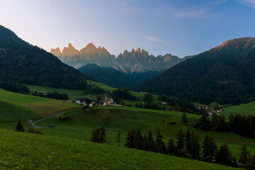 Obraz premium View above the Villnößtal Val di Funes with view on the Geislerspitzen Odlegruppa during sunrise warm light golden hour