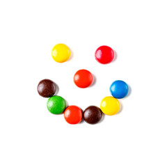 スマイルマークのように並べた丸いタブレット型のカラフルなチョコレートのお菓子　白背景の切り抜き