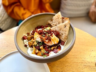 Turkish eggs Cilbir and fresh pita bread for traditional Turkish breakfast served on plate