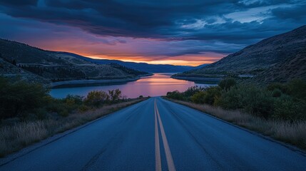Fototapeta premium The empty road leading to the lake by sunset
