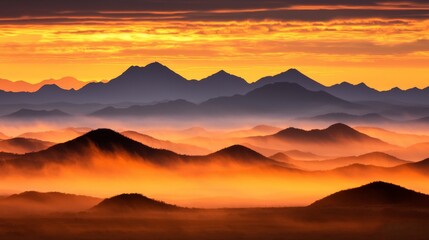 Obraz premium Majestic sunrise illuminates layers of misty mountains, creating a breathtaking landscape view.