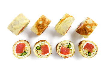 Homemade crepe rolls stuffed with salted salmon, cream cheese and fresh cucumber. Delicious appetizer. isolated on white background, top view