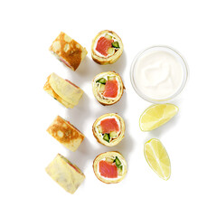 Homemade crepe rolls stuffed with salted salmon, cream cheese and fresh cucumber. Delicious appetizer. isolated on white background, top view