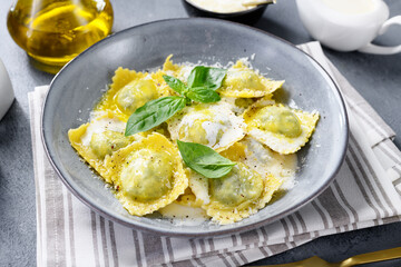 Homemade Ravioli pasta with spinach and ricotta cheese filling with creamy white sauce and grated Parmesan cheese. 