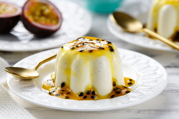 Panna cotta dessert with fresh passion fruit sauce on white wooden background