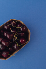 Fresh cherry in cardboard packaging on background. Healthy raw food, dessert without sugar and...