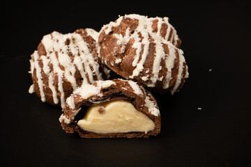 Profiteroles with coconut cream on a black background.
