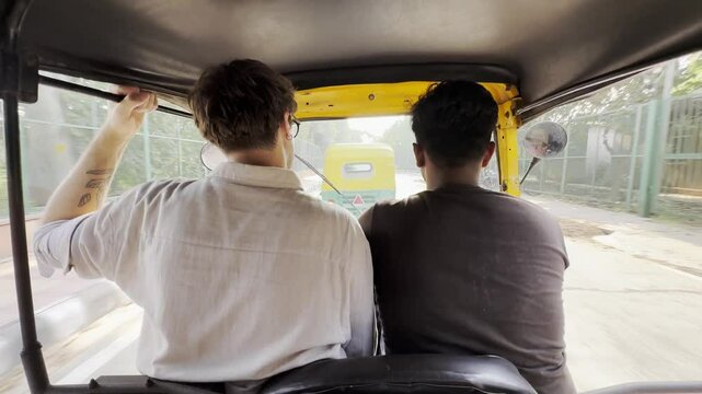 Back view of an auto rickshaw on an urban street in Delhi. Dynamic motion, traditional Indian transportation, authentic local culture, bustling city commute, and vibrant travel scene.
