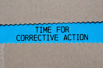 Time for corrective action message written on ripped torn paper on blue background. Conceptual time...