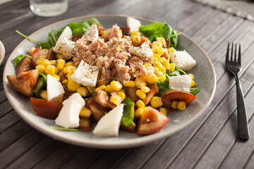 Fish salad with canned tuna and corn, tomatoes and arugula