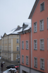 Obraz premium Blurred image of Snow falling - with windows, building on the background.