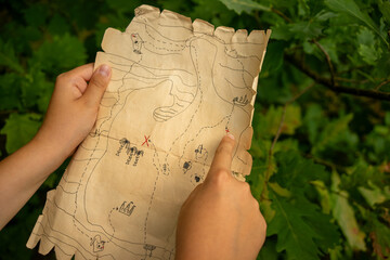 A quest map featuring treasure island and pirate symbols. Outdoor camping games with children. Treasure hunt.