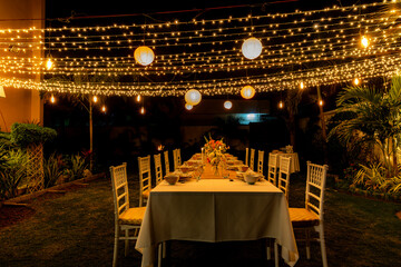 Summer winter candle light dinner party theme with fine dinning arrangements fairy lights and...