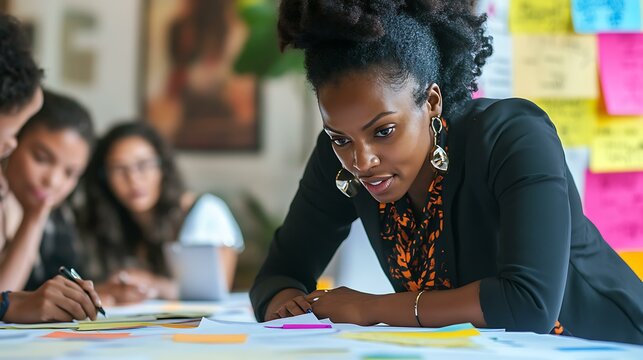 A Black businesswoman engaging her diverse team during a planning session in a clean, professional environment