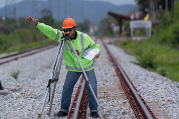 Surveyor builder site engineer with theodolite total station at Railway site outdoors during surveying work
