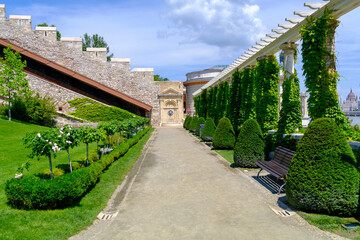 A scenic path in a beautiful park with a stone wall backdrop
