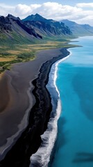 Fototapeta premium Dramatic coastal landscape features black sand beach meeting vibrant blue ocean under clear sky