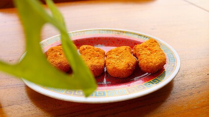 Golden Crispy Chicken Nuggets on a Plate on Wooden Table