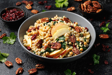 Warm barley pearl salad with kale, dried cranberries, apples and roasted pecan nuts. Healthy food
