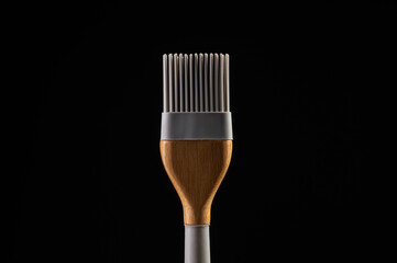 Generated imageCulinary silicone brush with wooden handle on black background. Perfect for cooking, baking, kitchenware and food styling concepts. Minimalism and style in the details.
