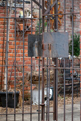 Old rusty gate showing a cluttered courtyard 
