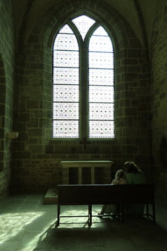 People sitting in front of a church window