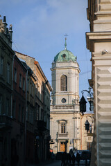 View of an old narrow street in Lviv, Ukraine. Tower of the Dominican Church and Monastery.