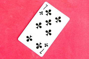 Seven of Club playing card, red background.