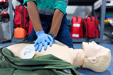 Close-up of middle-aged Asian male hands performing cardiopulmonary resuscitation (CPR) on a...