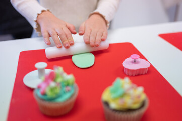 Young girl decorating cupcakes during a baking class preparing muffins and cupcake for birthday party celebration