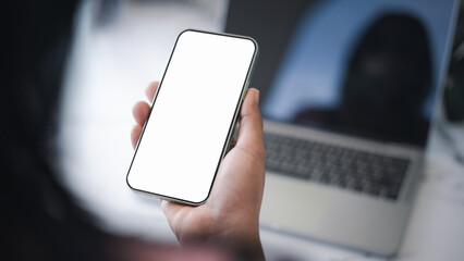 Cell phone white screen mockup, Human hand holding mobile phone with blank screen while working at office, Design creative work space, Businessman using smartphone, Social media advertisement.