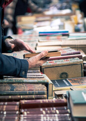 Man buying second hand books  at a flea market. 
Recycling concept