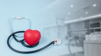 Red heart love shape hand exercise ball with doctor physician stethoscope on hospital background,...