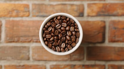 A top-down view of a white bowl filled with coffee beans, set against a rustic brick background.
