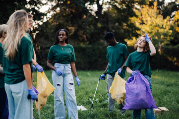 Group of volunteers picking up trash in park