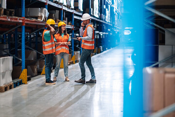 Warehouse workers discussing logistics while manager is talking on the phone