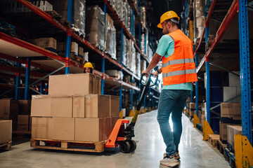 Warehouse worker moving boxes on a pallet using a manual pallet jack